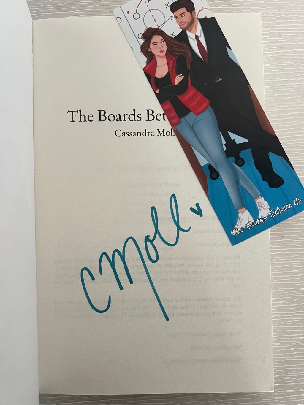 The Boards Between Us by Cassandra Moll signed paperback edition with bookmark